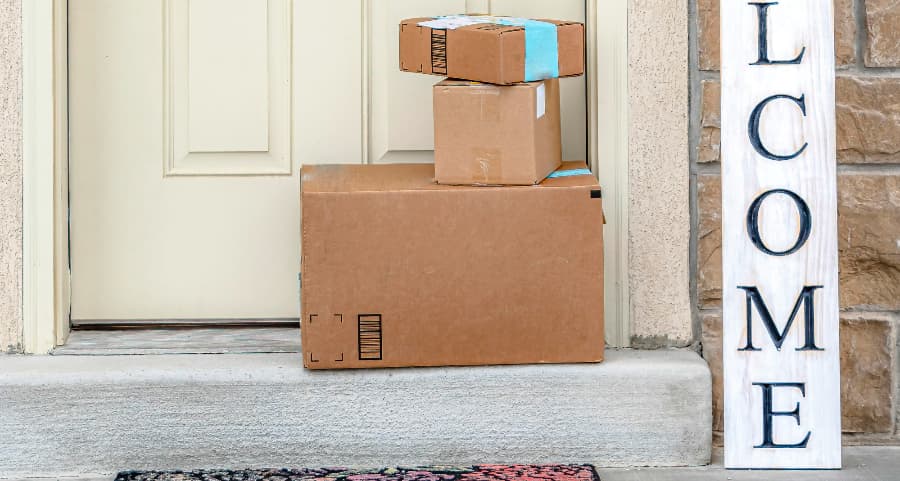 Packages on the doorstep of a home with a welcome sign in Detroit